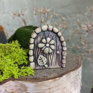 Miniature Fairy Door with flower and leaf decoration.