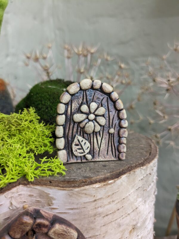 Miniature Fairy Door with flower and leaf decoration.